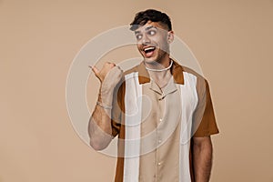 Brunette young man laughing and pointing finger aside