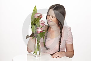 Brunette young woman enjoys a bouquet of roses