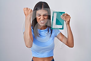 Brunette young woman holding l sign for new driver annoyed and frustrated shouting with anger, yelling crazy with anger and hand