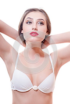 Brunette young woman with red lips in white underwear is looking to the side on a white copy space background isolated