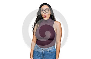 Brunette young woman wearing casual clothes and glasses afraid and shocked with surprise expression, fear and excited face