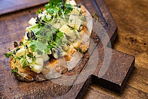 bruschetta with cheese and greens on a wooden cutting board for photos