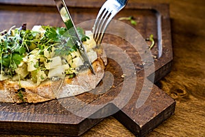 bruschetta with cheese and greens on a wooden cutting board for photos