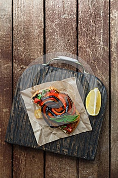 Bruschetta with grilled aubergine, bell pepper and basil, top view, place for copy