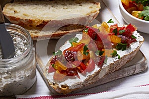 Bruschetta from homemade bread with cottage cheese and sprat pate and tomatoes on a wooden background. Rustic style.