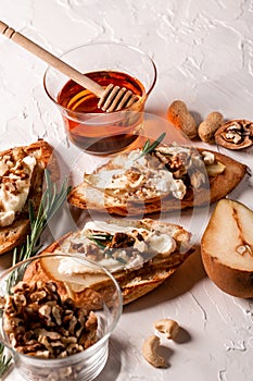 Bruschetta with pear, cheese camembert nuts and honey. Food recipe background. Close up