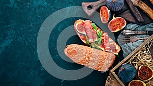 Bruschetta with prosciutto, fresh figs and cheese. On the old background. Healthy food. Free space for text.