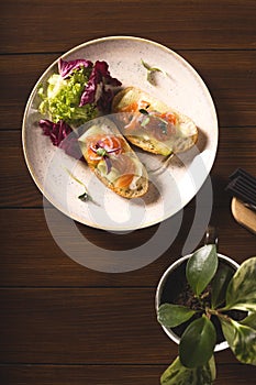 Bruschetta with salmon and cucumber on a plate with greens.