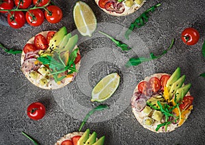 Bruschetta with tomato, avocado, herbs and arugula. Rustic background. Top view photo