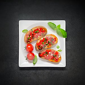 Bruschetta with Tomato and Basil on White Plate