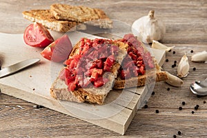 Bruschetta with tomatoes on rustic wood background