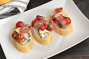 Bruschetta Topped with Baked Feta, Grape Tomatoes and Fresh Herbs
