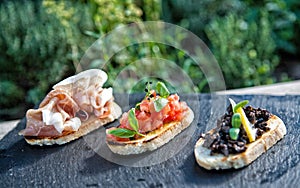 Bruschette with prosciuto and tomatoes and olives photo