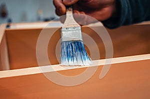 The brush applies varnish to furniture. Varnishing furniture with varnish