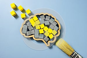 A Brush, brain shape with yellow and gray cubes. Cognitive Behavioral Therapy CBT concept.