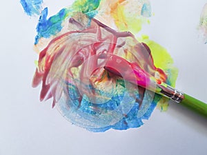 Brush with bright paints drawing on a white background hobbies