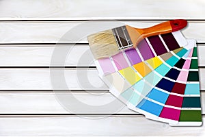 Brush and bright palette of colors on wooden