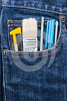 Brush, cutter and screwdriver in blue jean pocket