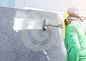 a brush dipped in hydrochloric acid mixed with water to scrub the surface exposed aggregate finish wall