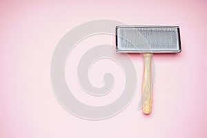 Brush for dogs on a pink background, space for text, flat lay. Grooming brush