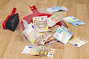 Brush with euros in garbage scoop