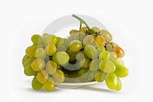 Brush green grapes lying on a plate, close-up. Isolated on white background