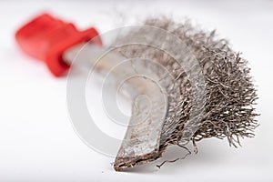 A brush with metal prongs on a white table. Tools for the slusier to clean the material