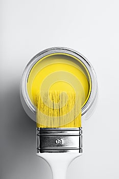 Brush on open can of yellow paint