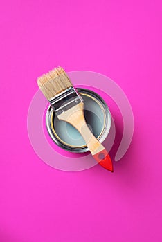 Brush and open paint can with on trendy yellow background. Top view, copy space. Appartment renovation, repair, building