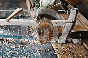 Brush process from gunpowder and web, wood planer and shavings at carpenters workshop, old woodworking tool, sawdust, antique saws