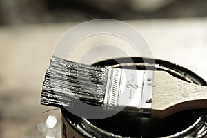 Brush resting on a tin can of protective paint