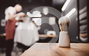 Brush for shaving beard along, blurred background of hair salon for men, barber shop