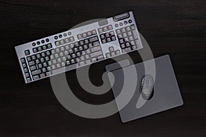 Black keyboard, mouse and mousepad on desk.