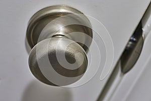 Brushed Metal Doorknob Detail, White Door Edge, Eye-Level Perspective