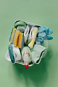 Brushes, bottles with cleaning liquids, sponges, and rubber gloves. Cleaning supplies on wooden floor