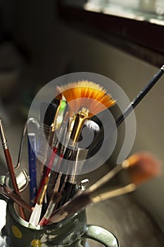 brushes of different size and thickness inside a ceramic container on a table