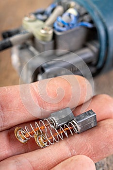 Brushes for electric motor on a workbench. Spare parts for angle grinders