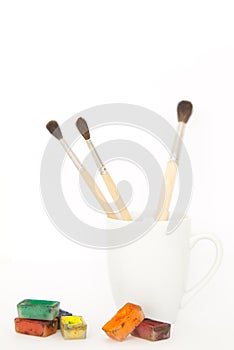 Brushes in a mug with paints