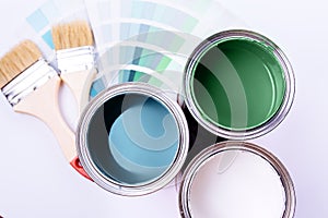 Brushes and an open can with red on plain gray background