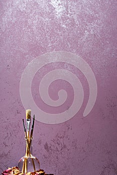 Brushes on a painted wall background.