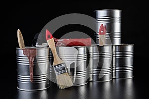 Brushes for painting with paint and cans on a workshop table. Painting accessories prepared for painting