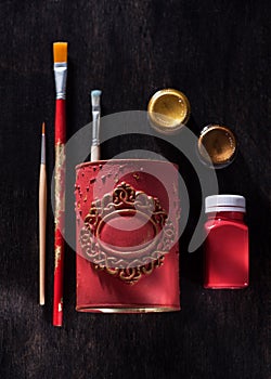 Brushes and paints for drawing in a container with decorative molding. Artistic tools for workshop and creativity