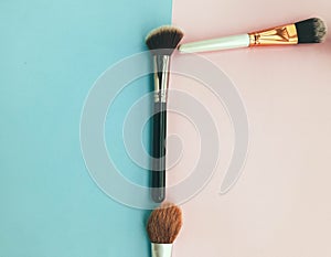Brushes on a pink-blue background. glamorous makeup artist. personal care, decorative cosmetics. natural bristle makeup brushes