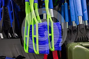 brushes and scrapers for cleaning car snow hang in the supermarket