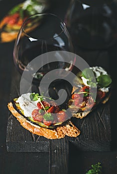 Brushetta with eggplant, tomatoes, garlic, cream-cheese, arugula, glass of wine