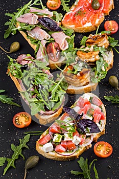 Brushetta set for wine. Variety of small sandwiches with prosciutto, tomatoes, parmesan cheese, fresh basil