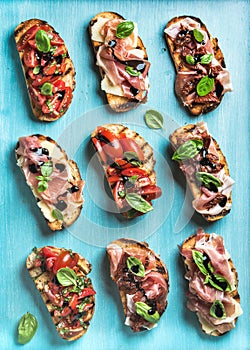 Brushetta set for wine. Variety of small sandwiches on turquoise blue backdrop, top view