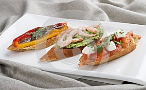 Brushetta snacks for wine. Variety of small sandwiches on a textile background