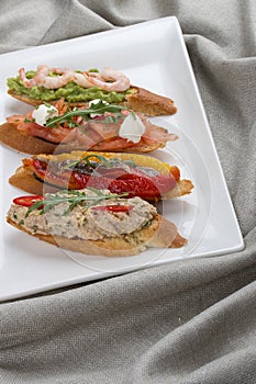 Brushetta snacks for wine. Variety of small sandwiches on a textile background