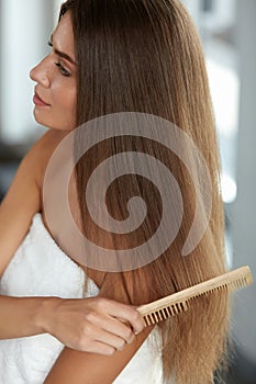 Brushing Hair. Woman Hairbrushing Beautiful Long Hair With Comb